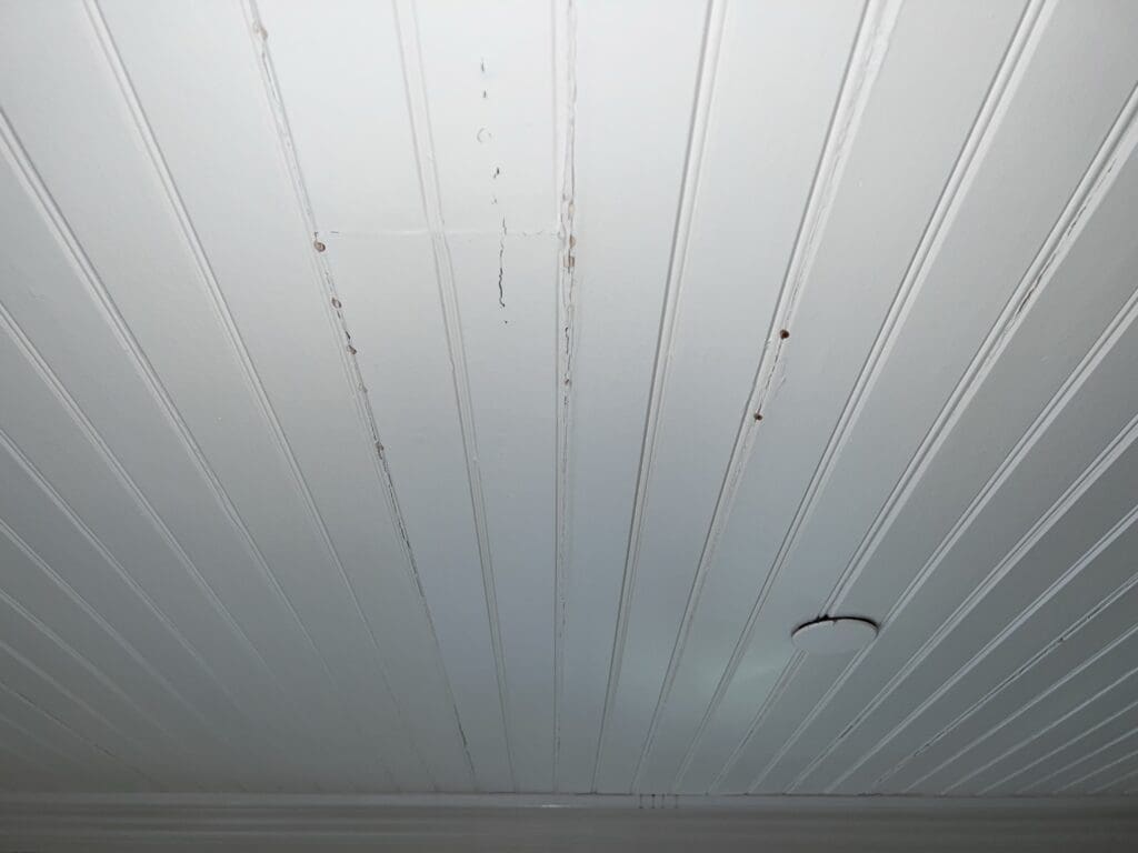 White paneled ceiling with some visible stains and marks.
